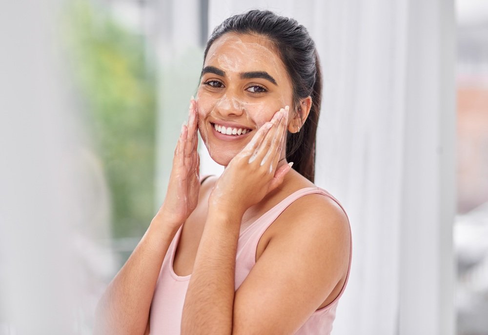 i-love-how-this-product-makes-my-skin-feel-cropped-shot-young-woman-washing-her-face-bathroom